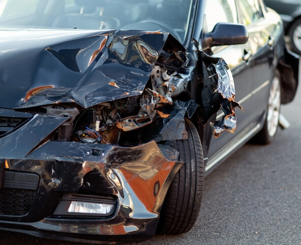 Close-up of damaged car part after accident showing broken metal and scratches